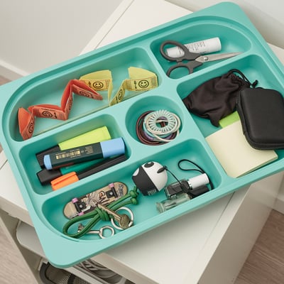 Turquoise TROFAST tray organizes kids small items like pens, keys, and toys. Compartments help keep things neat and easy to find.