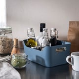 Blue UPPDATERA plastic box holding bottles, jar on table, small, organiser.