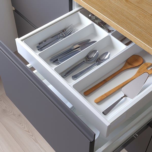 Open drawer organizer in kitchen with cutlery and utensils neatly arranged.