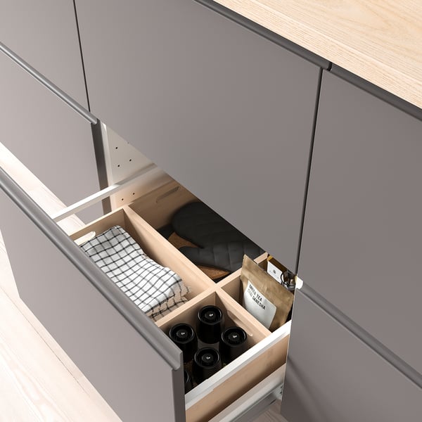 Open drawer showing organized items: bottles, cloth.