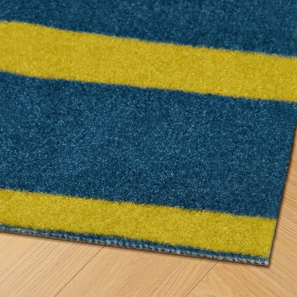 Striped blue and yellow doormat, showcasing vibrant colors and quality material, placed on a wooden floor.