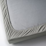 Grey fitted bed sheet with elastic corners on a white background.