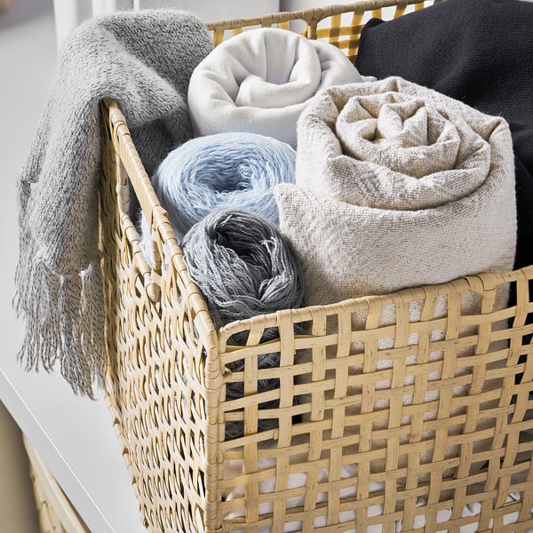 VÄXTHUS basket holds rolled blankets in neutral tones. Woven artificial rattan, sturdy handles, fits larger items.