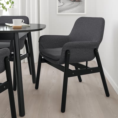 Modern dining setup with VEDBO chair, table, mug, and napkin.