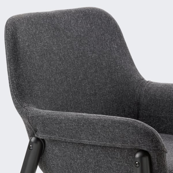 Close-up of a grey fabric armchair, showcasing high-quality upholstery and sturdy black metal legs.