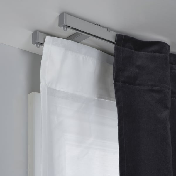 Ceiling-mounted VIDGA brackets support double curtains for light control and privacy, enhancing ceiling height.