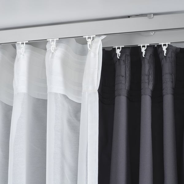 Image shows VIDGA curtain brackets hanging white and black curtains, demonstrating dual-layer light and privacy control.