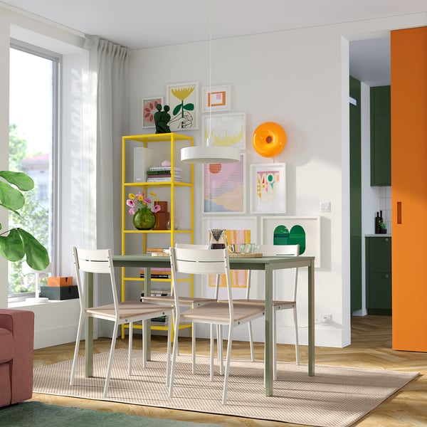 Modern dining area with yellow table, colorful wall art, and large window.
