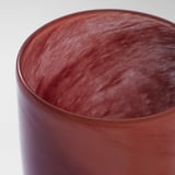 Close-up of handcrafted red glass candle holder with intricate patterns, showcasing high-quality craftsmanship.
