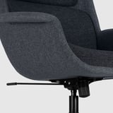 Een close-up van een moderne, verstelbare bureaudraaistoelbasis. Het strakke design is een zwarte gaslift en stevige armleuningen, wat zorgt voor comfort en stabiliteit.