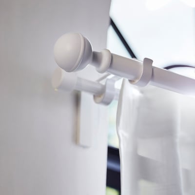 Paar witte bolvormige gordijnstangen, gemaakt van gerecycled polypropyleenplastic.