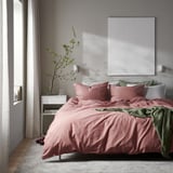 Moderne slaapkamer met roze ÄNGSLILJA beddengoed, groene plaid, nachtkastje met vaas, groot wit canvas en gedrapeerde gordijnen. Minimalistisch en rustig.