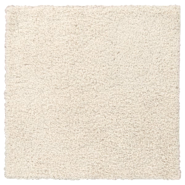 Een wit, zacht, vierkant vloerkleed met een ruige textuur, gemaakt van polypropyleen en synthetisch rubber voor een comfortabel gevoel.