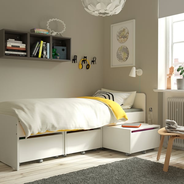 Moderne slaapkamer met ÄRENDE grijs tapijt, wit bed, planken en muurdecoratie.