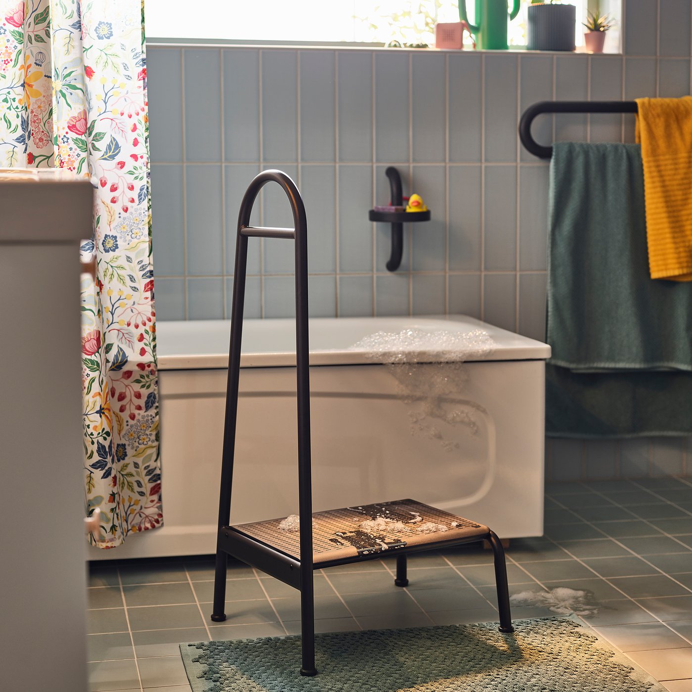 Zwarte BÄSINGEN kruk in de badkamer helpt bij veilig baden, antislip, stabiel, donkergrijs frame.