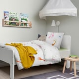 Kinderslaapkamer met giraf beddengoed, boekenplank, luifel.