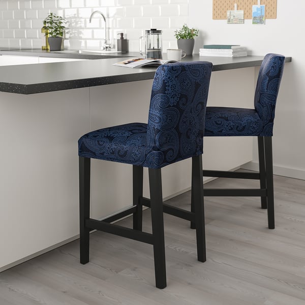 Blauwe paisley barkrukken met zwarte poten bij modern keukeneiland.