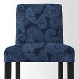Een stevige, elegante stoel met ingewikkelde blauwe paisley bekleding en houten poten, die comfort en stijl uitstraalt.