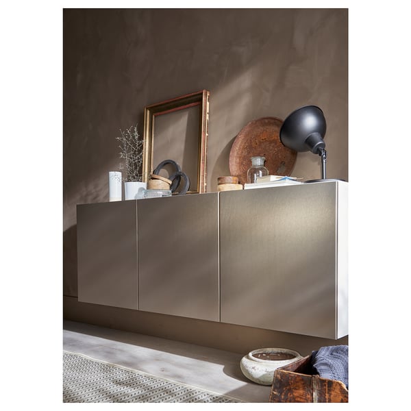 Modern grijs wandopbergmeubel met strakke handgrepen en diverse decoratieve items bovenop.