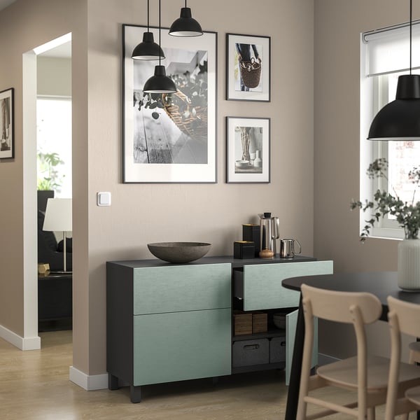 Moderne kamer met groenblauw BESTÅ opbergmeubel, zwarte hanglampen en houten stoel.