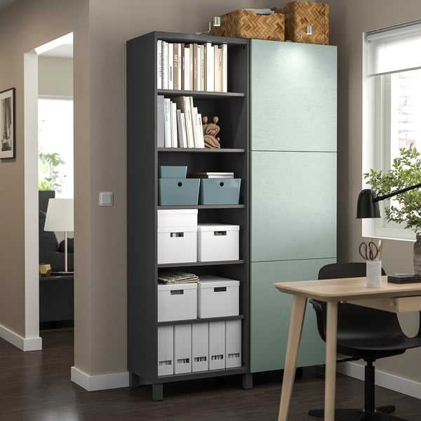 Modern thuiskantoor met BESTÅ opbergers, donkere planken, houten bureau, zwarte stoel, groene kast.