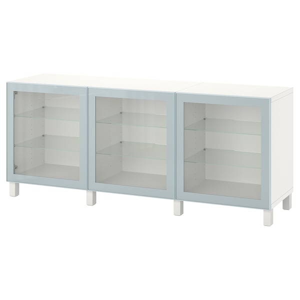 Een witte BESTÅ kast met drie glazen deuren. Het heeft een strak, modern ontwerp met glazen planken aan de binnenkant.