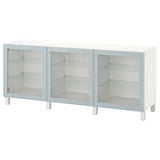 Een witte BESTÅ kast met drie glazen deuren. Het heeft een strak, modern ontwerp met glazen planken aan de binnenkant.