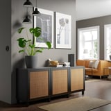 Moderne woonkamer met BESTÅ dressoir, boeken, luidspreker, plant en oranje banken.