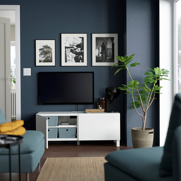 Moderne woonkamer met BESTÅ tv-meubel, verstelbare planken, soft-close deuren, flatscreen-tv, turquoise stoelen en plant.