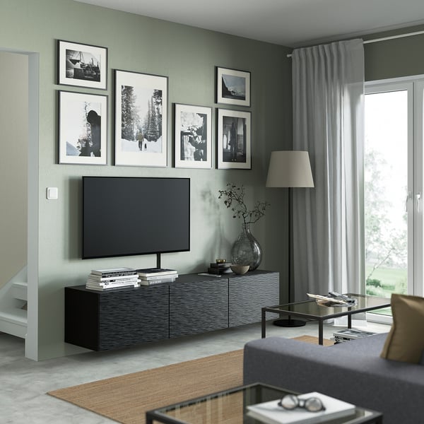 Moderne woonkamer met BESTÅ tv-meubel, flatscreen-tv en kunstwerken. Groot raam, grijze bank en salontafel maken het ontwerp compleet.