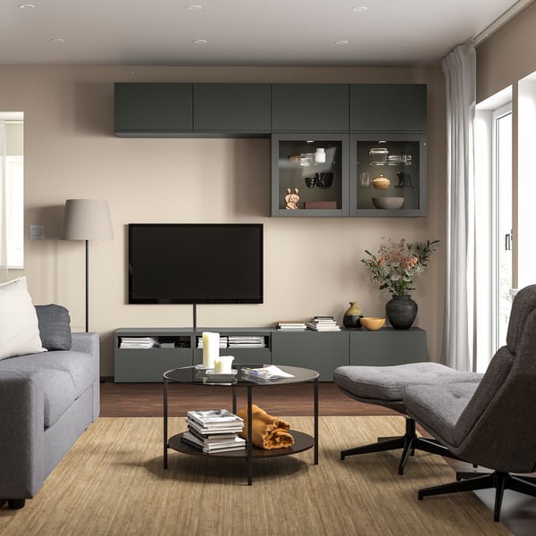 Moderne woonkamer met BESTÅ grijs tv-meubel, ruime planken en strak design; Inclusief een bank, salontafel en decoratieve voorwerpen.