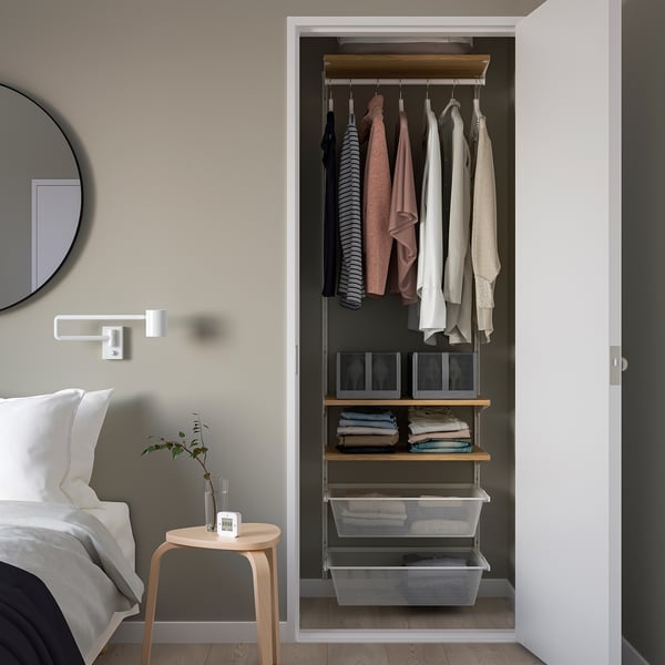 BOAXEL kast: aan de muur gemonteerd, georganiseerd met kleding en manden, perfect voor kleine ruimtes.