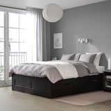 BRIMNES zwart bed met 4 lades, onopvallend, geïntegreerde verlichting, neutraal beddengoed, doorschijnende gordijnen, warm tapijt.