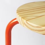 Moderne rood metalen kruk met licht houten zitting, gladde randen.