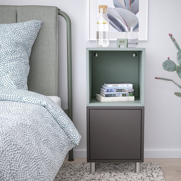 Modern nachtkastje met EKET grijze kast, boeken, groen hoofdeinde en cactus.