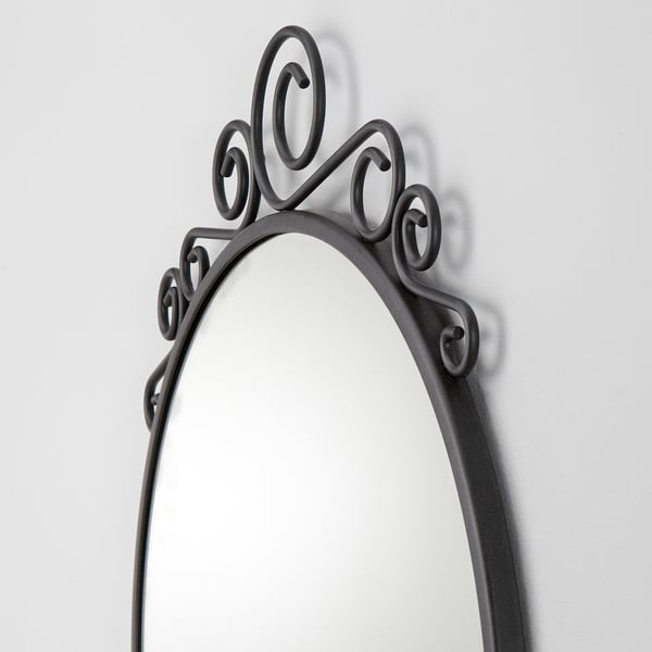 Sierlijke zwarte spiegel met ingewikkeld wervelend frame van staaldraad.