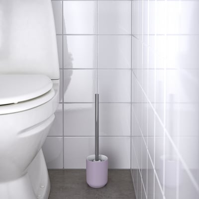Paarse toiletborstel in houder, geplaatst bij wit toilet, voor eenvoudige reiniging.