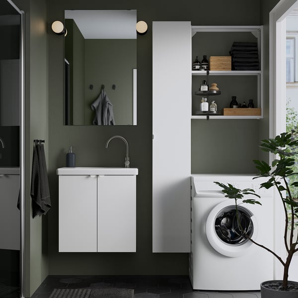 Moderne badkamer met ENHET badmeubel, spiegel, verlichting, wasmachine, plant, zwart vloerkleed, grijze handdoeken, op de natuur geïnspireerde kleuren.