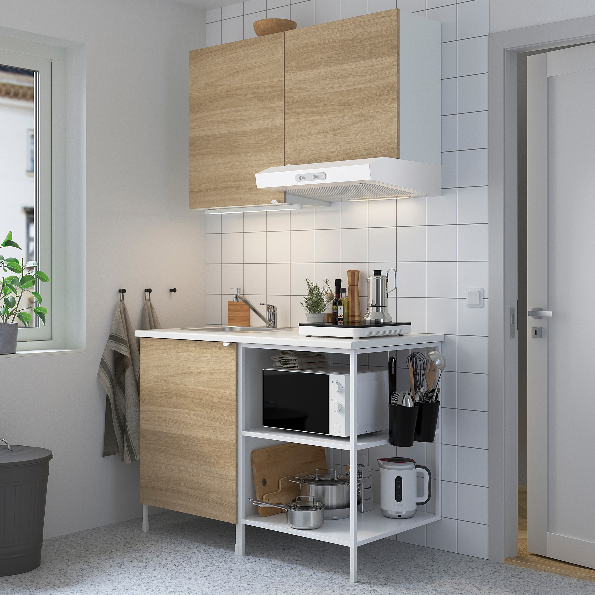 Moderne compacte keuken, voorzien van ENHET lichthouten kasten en witte apparaten. Afmeting: 130 cm.