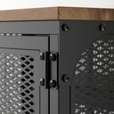 Close-up van de hoek van de FJÄLLBO-opbergtafel, met robuuste metalen verbindingen met houten blad, met de nadruk op een kwaliteitsconstructie.