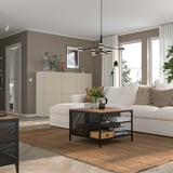 Moderne woonkamer met witte bank, salontafel en bloemen.