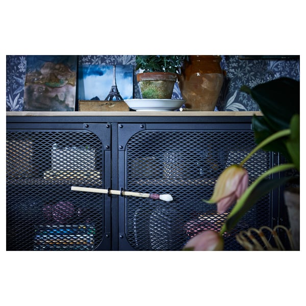 Zwarte metalen en houten opslagruimte met gaasdeuren, met potplanten en foto's.