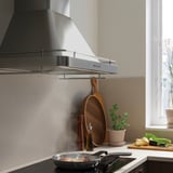 Moderne keuken met roestvrijstalen FÖLJANDE afzuigkap, led-verlichting en kookpan.