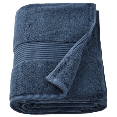 De FREDRIKSJÖN-handdoek is diepblauw, dik en zacht met een getextureerde rand en een opgerolde vorm.