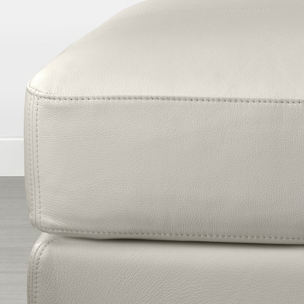 Moderne wit lederen voetenbank met nette stiksels, met een strak en comfortabel ontwerp. Perfect om te ontspannen.