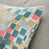 Kleurrijk, zacht sierkussen op de bank, ontworpen met gerecycled katoen. Levendige geometrische print, hoes met ritssluiting.