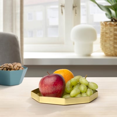 Gouden dienblad met fruit, noten, lamp.
