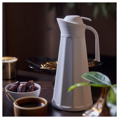 Witte thermosfles met dadels, koffie en plant. Strak, geribbeld ontwerp.
