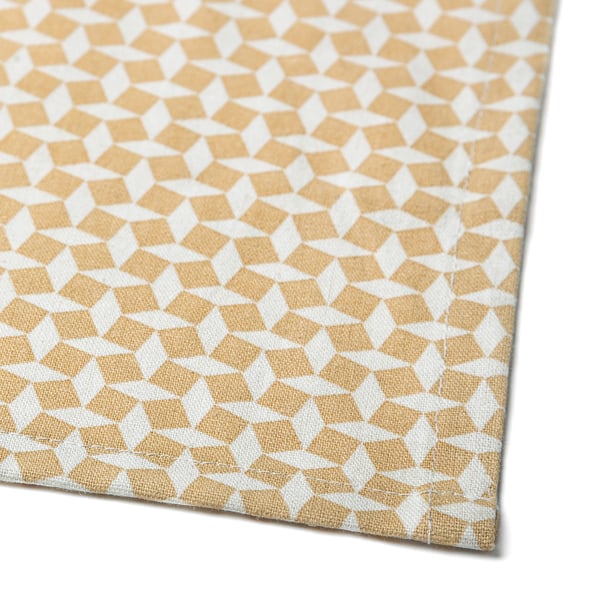 Een close-up van een beige en wit tafelkleed met een mozaïekontwerp, dat de geweven textuur en het hoogwaardige vakmanschap laat zien.