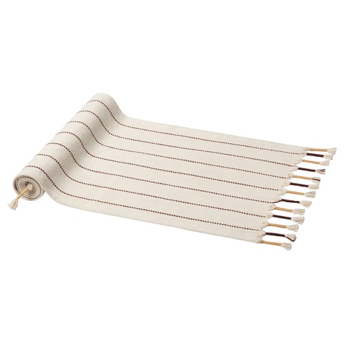 Een GOKVÄLLÅ tafelloper, beige, gemaakt van katoen en jute, met speelse kwastjes en een geweven patroon.